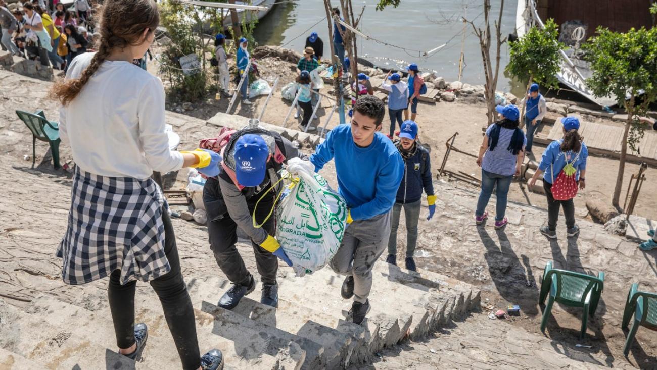 Refugee volunteers joined forces with locals to assist in the clean-up effort. © UNHCR/Pedro Costa Gomes  